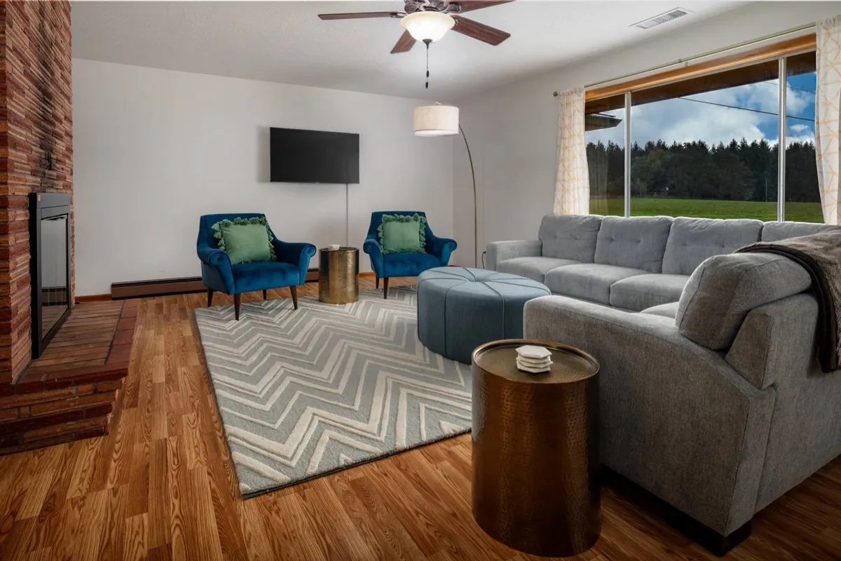 A welcoming living area featuring a cozy fireplace, plush sofa, accent chairs, and a coffee table. The window offers a view outside, connecting the interior comfort with the surrounding landscape. The mood is inviting, ideal for relaxing after a day of exploration.